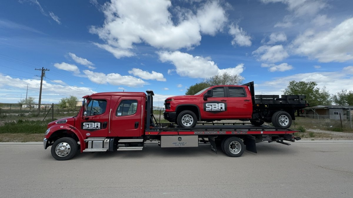 SBA tow truck transporting a service truck